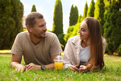 Photo of Couple spending time together on green lawn in park