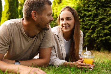 Photo of Couple spending time together on green lawn in park