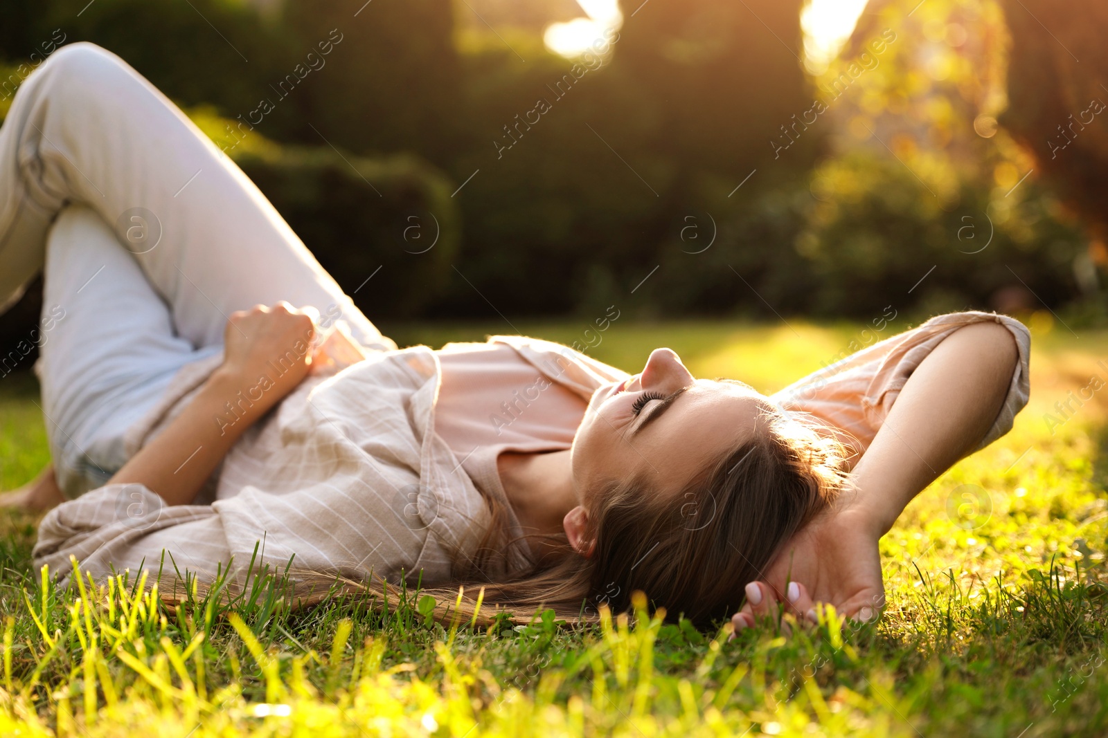 Photo of Woman resting on green lawn in park