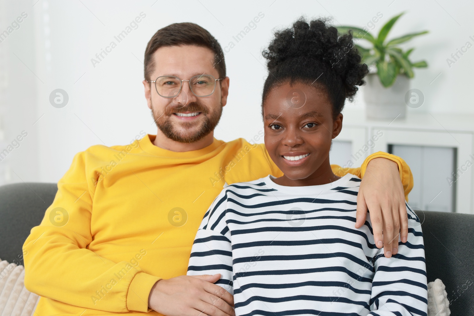 Photo of International relationships. Portrait of lovely couple on sofa at home