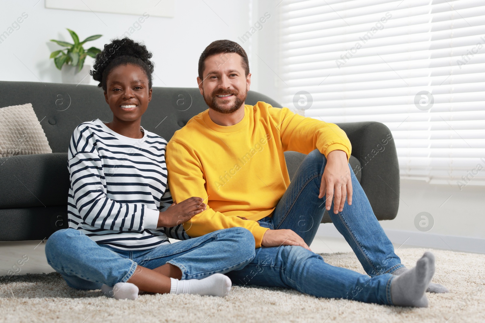 Photo of International relationships. Lovely couple spending time together on floor at home