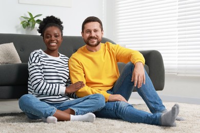 Photo of International relationships. Lovely couple spending time together on floor at home