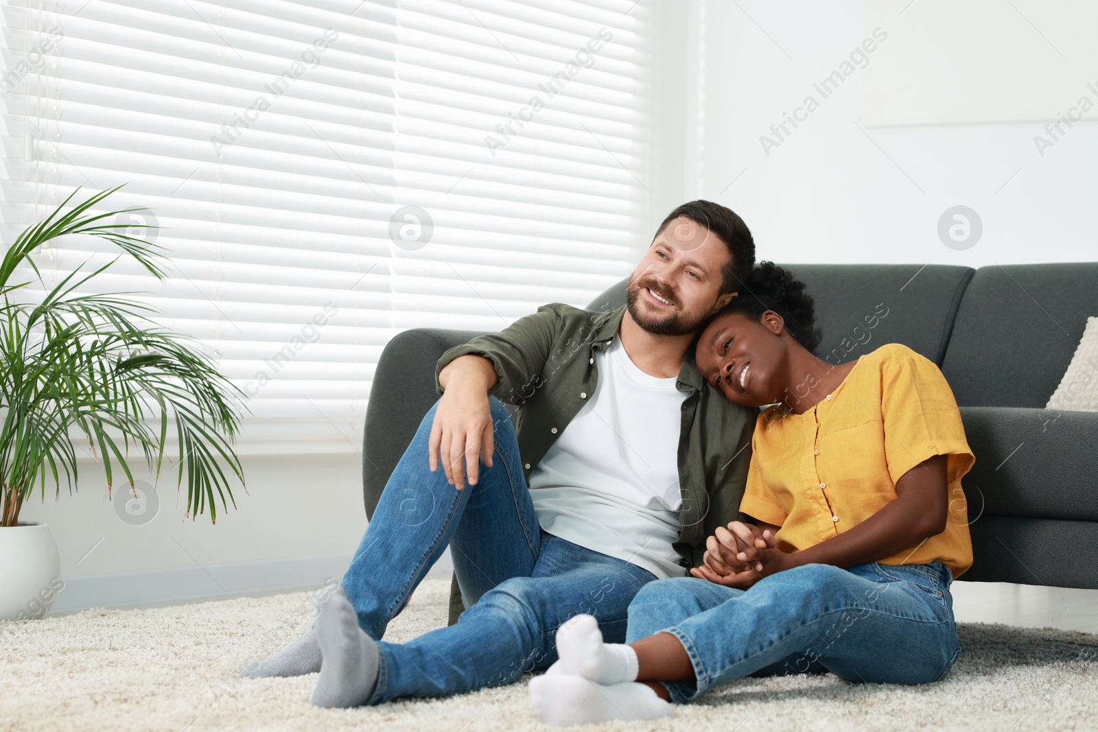 Photo of International relationships. Lovely couple spending time together on floor at home