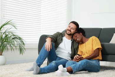 International relationships. Lovely couple spending time together on floor at home