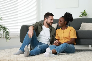 International relationships. Lovely couple spending time together on floor at home