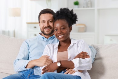 International relationships. Portrait of lovely couple on sofa at home