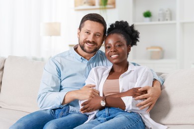 International relationships. Portrait of lovely couple on sofa at home