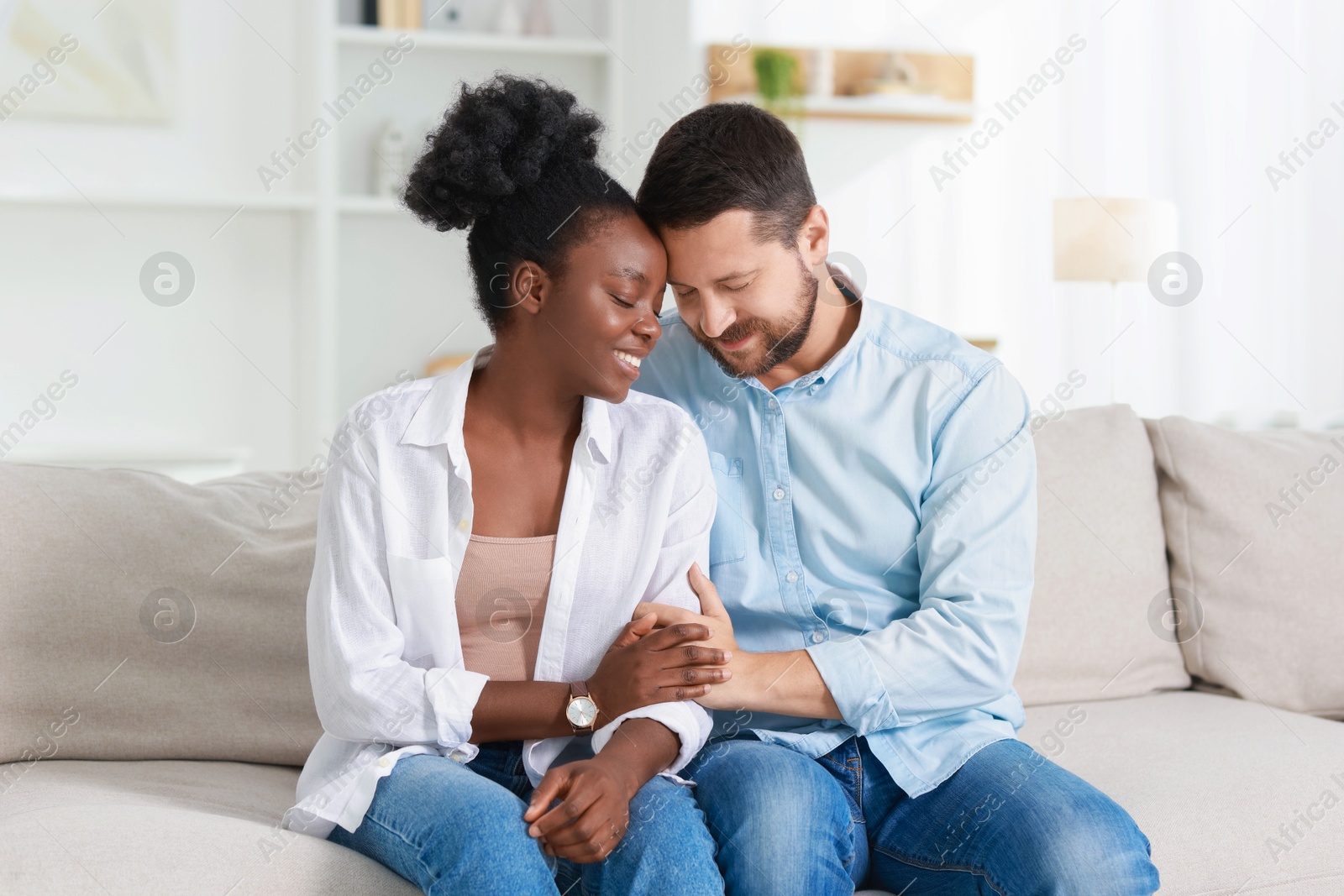 Photo of International relationships. Portrait of lovely couple on sofa at home