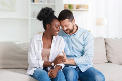 International relationships. Portrait of lovely couple on sofa at home