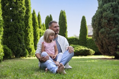 Photo of Father and his daughter spending time together on green lawn in park