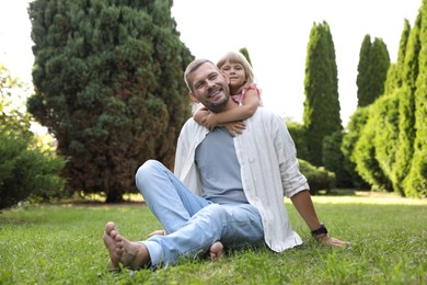 Photo of Father and his daughter spending time together on green lawn in park