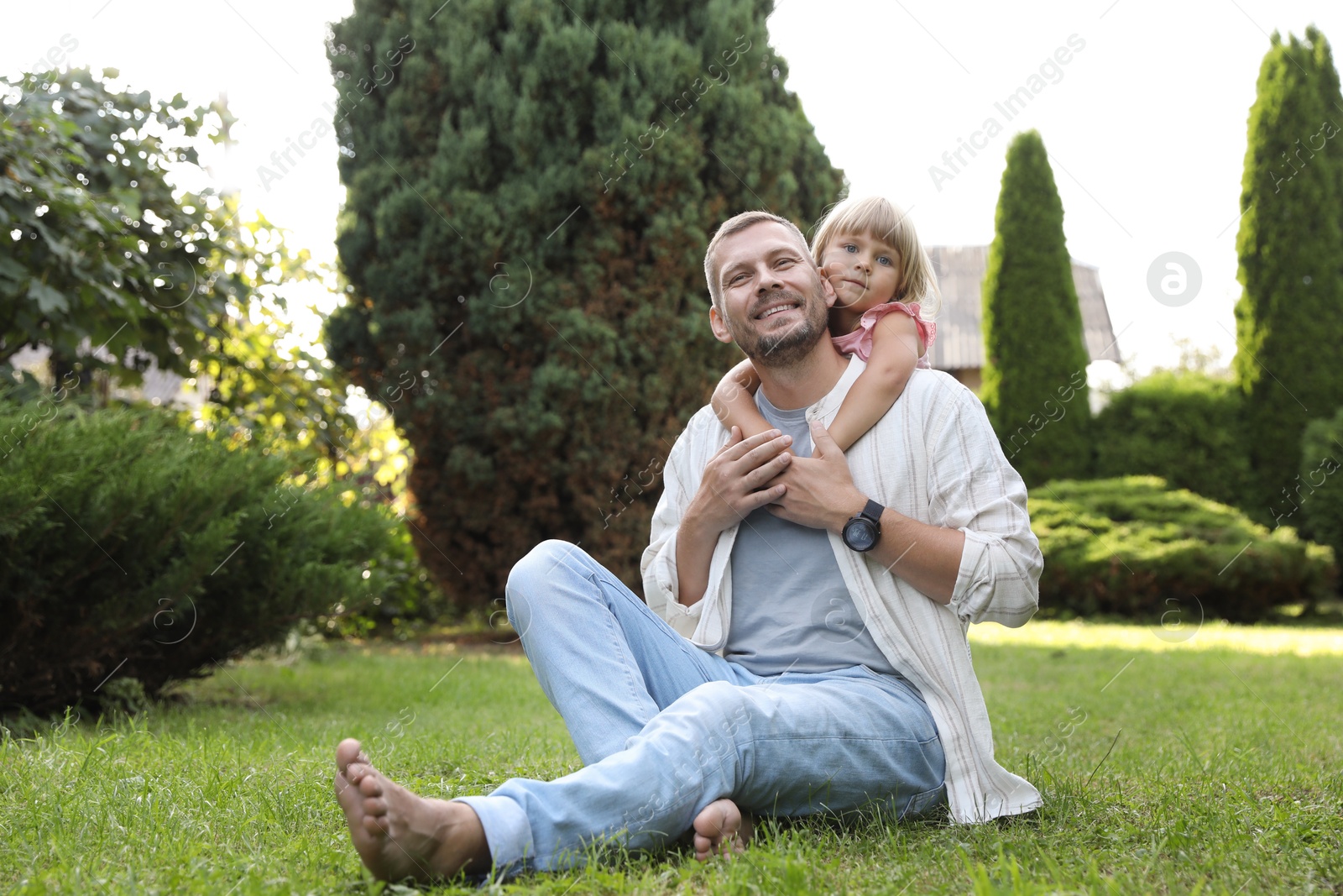 Photo of Father and his daughter spending time together on green lawn in park