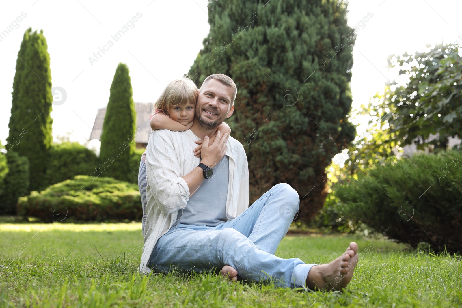 Photo of Father and his daughter spending time together on green lawn in park