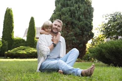 Father and his daughter spending time together on green lawn in park