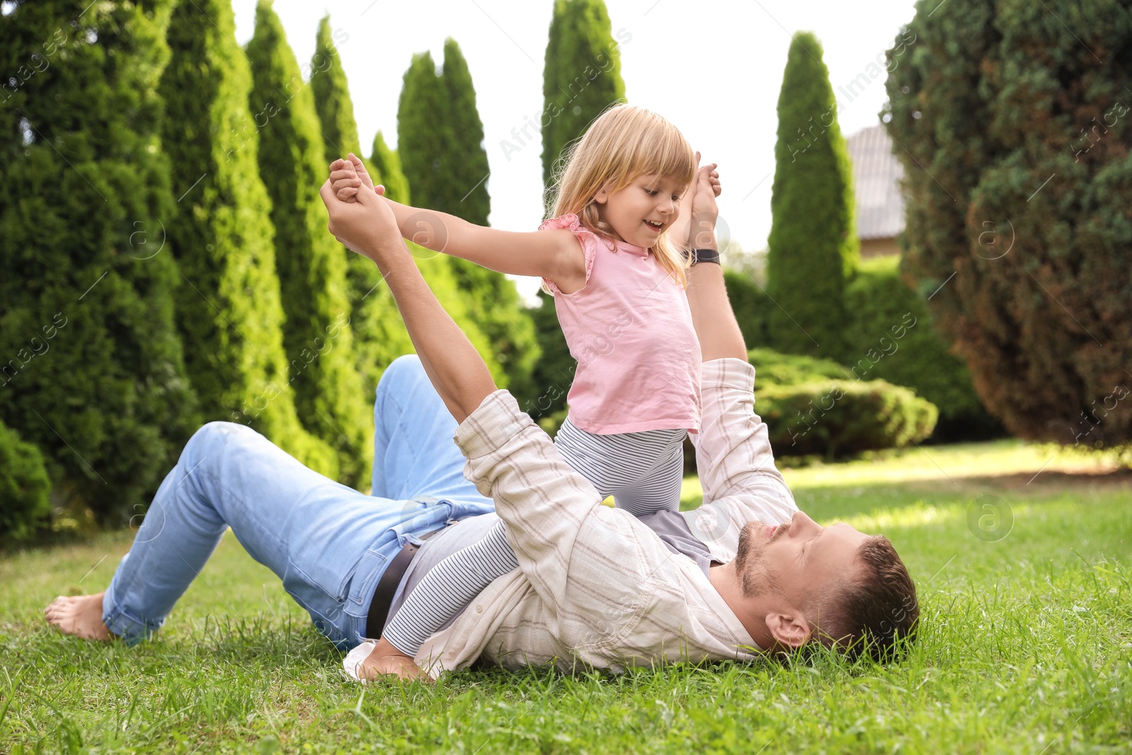 Photo of Father and his daughter spending time together on green lawn in park