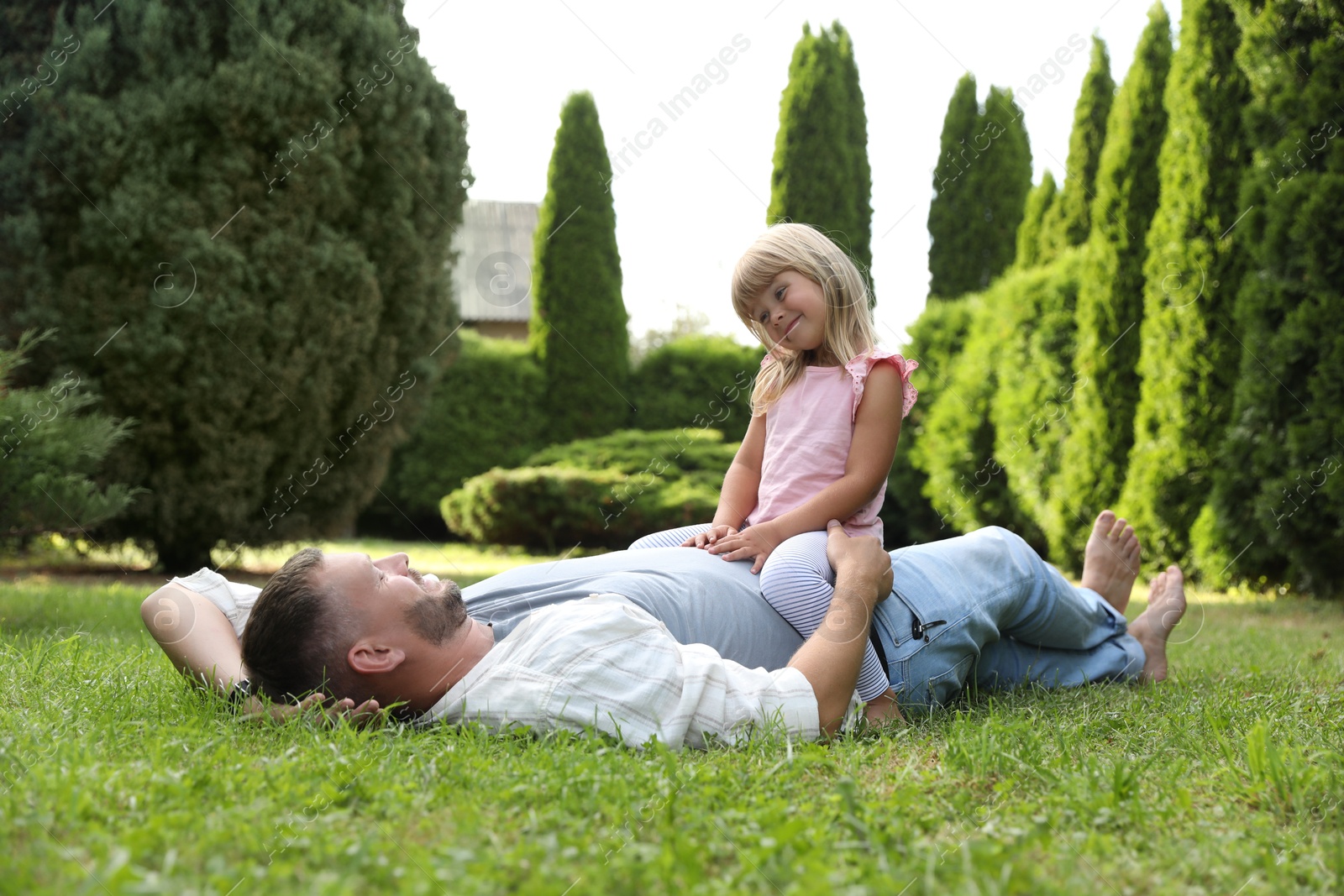 Photo of Father and his daughter spending time together on green lawn in park