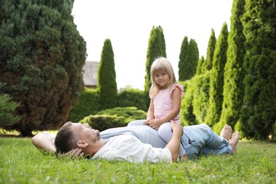 Photo of Father and his daughter spending time together on green lawn in park