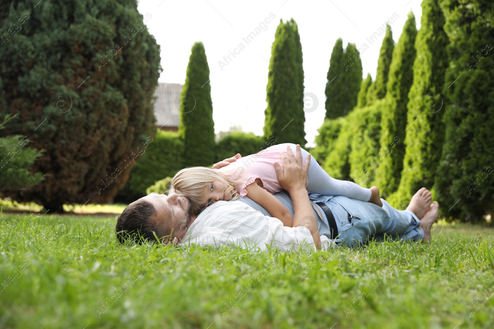 Photo of Father and his daughter spending time together on green lawn in park