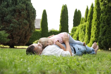 Father and his daughter spending time together on green lawn in park