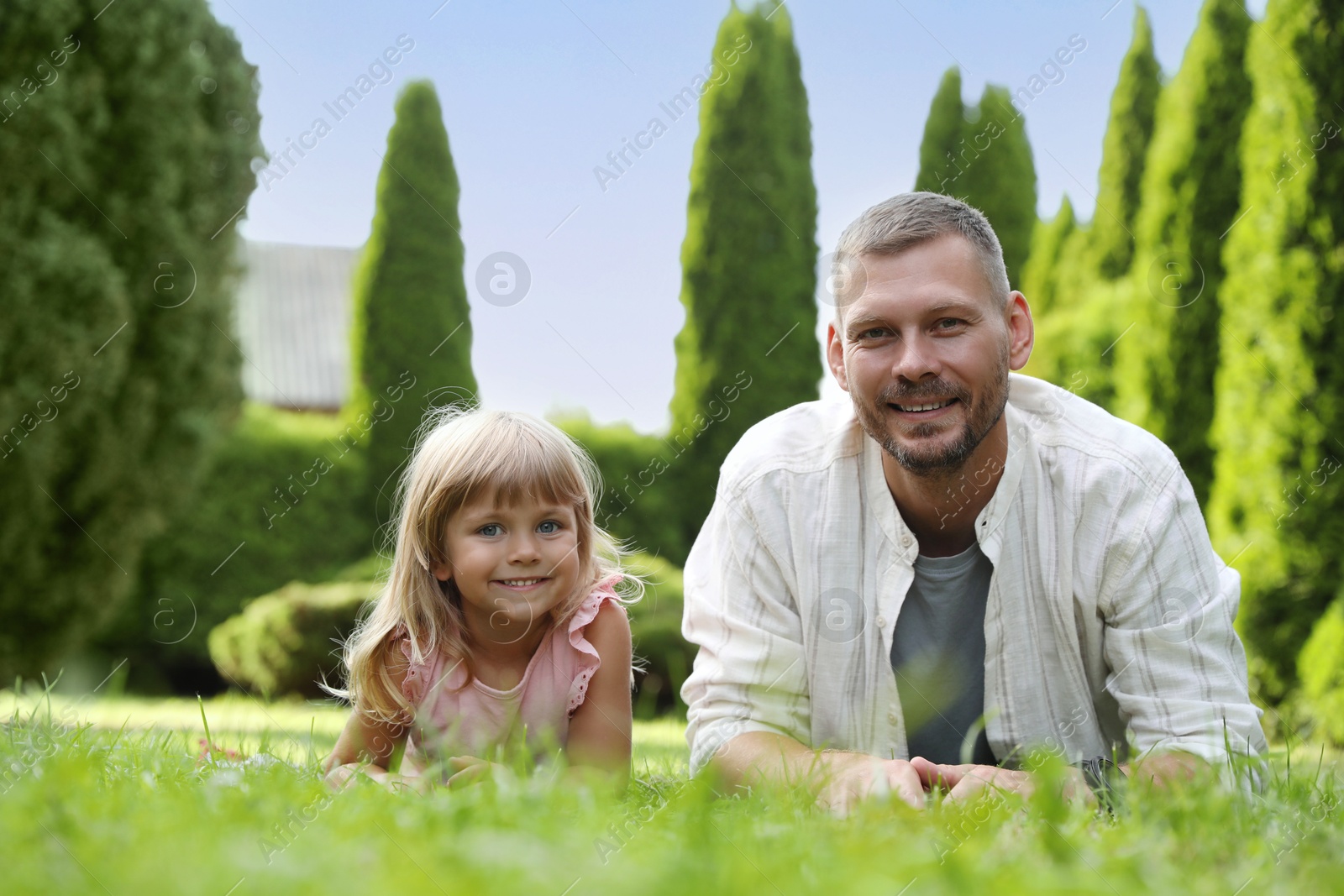 Photo of Father and his daughter spending time together on green lawn in park