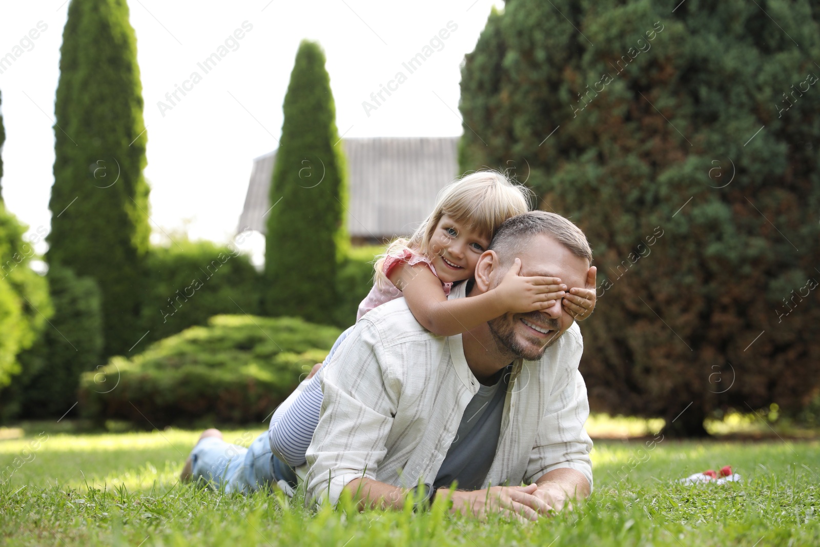 Photo of Father and his daughter spending time together on green lawn in park