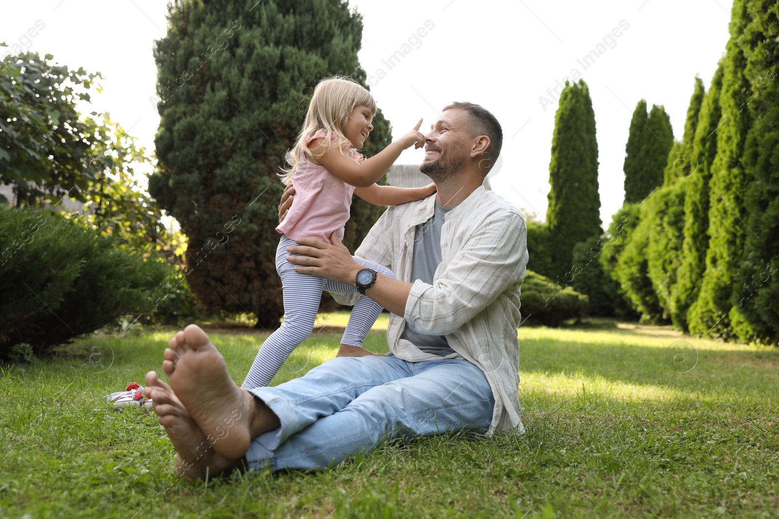 Photo of Father and his daughter spending time together on green lawn in park