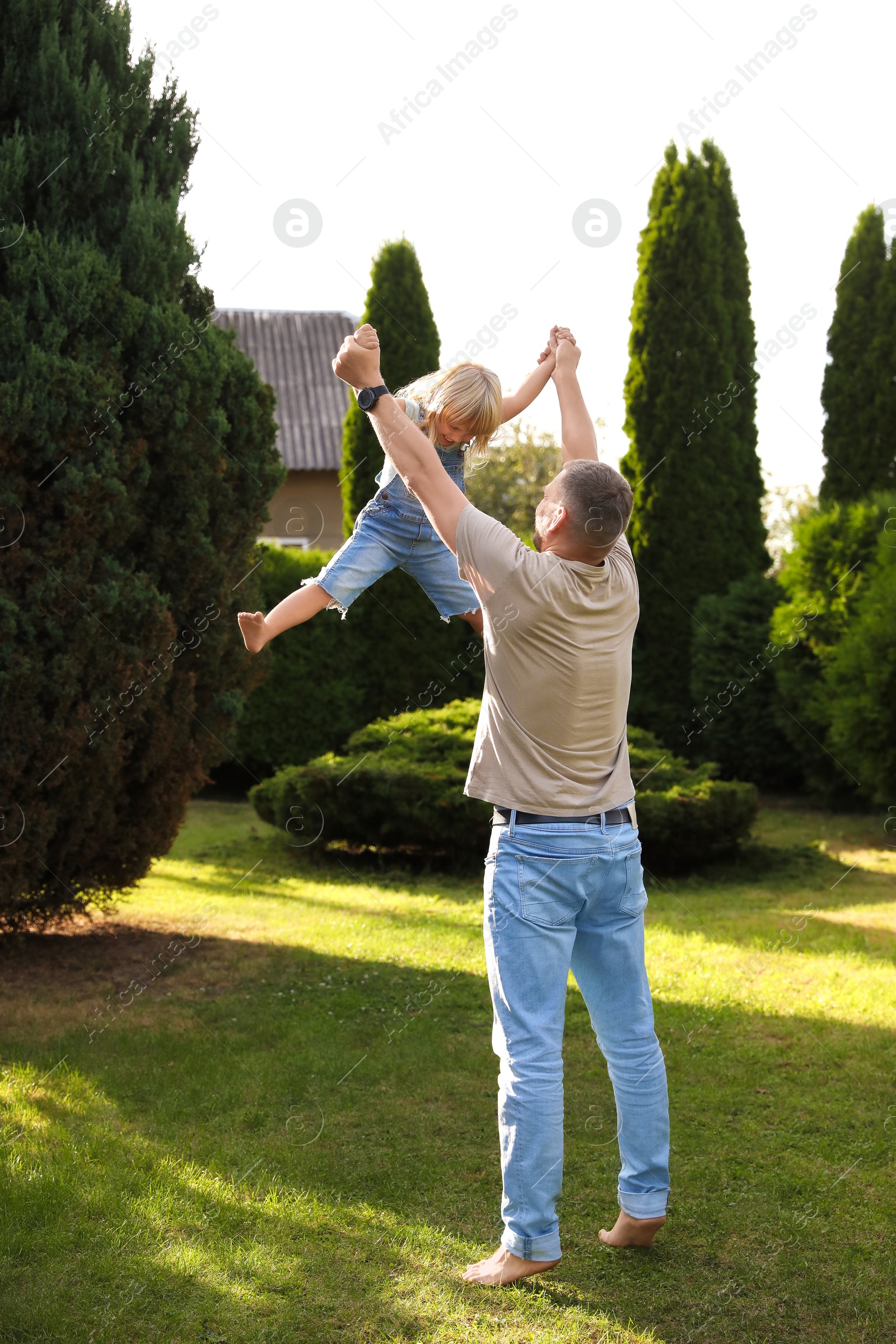 Photo of Father and his daughter spending time together on green lawn in park