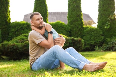 Father and his daughter spending time together on green lawn in park