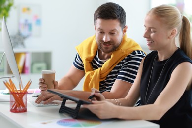 Designers with tablet working together at table in office