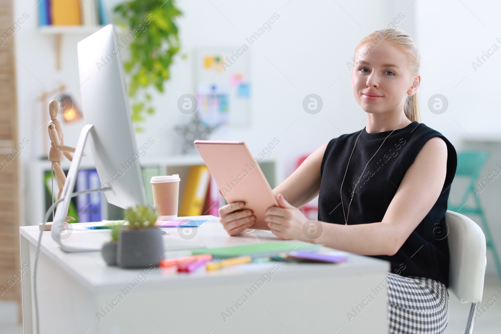 Photo of Designer working with tablet at table in office