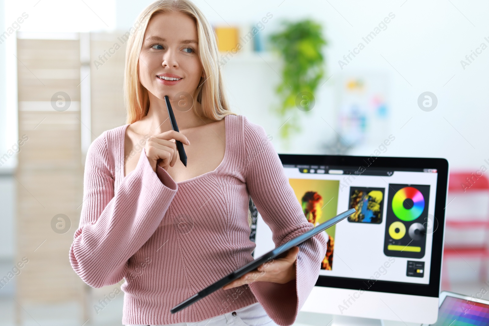 Photo of Beautiful young designer with tablet in office