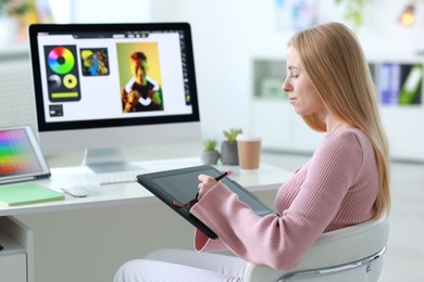 Photo of Young designer working with tablet in office