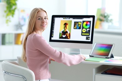 Graphic designer working with computer at table in office