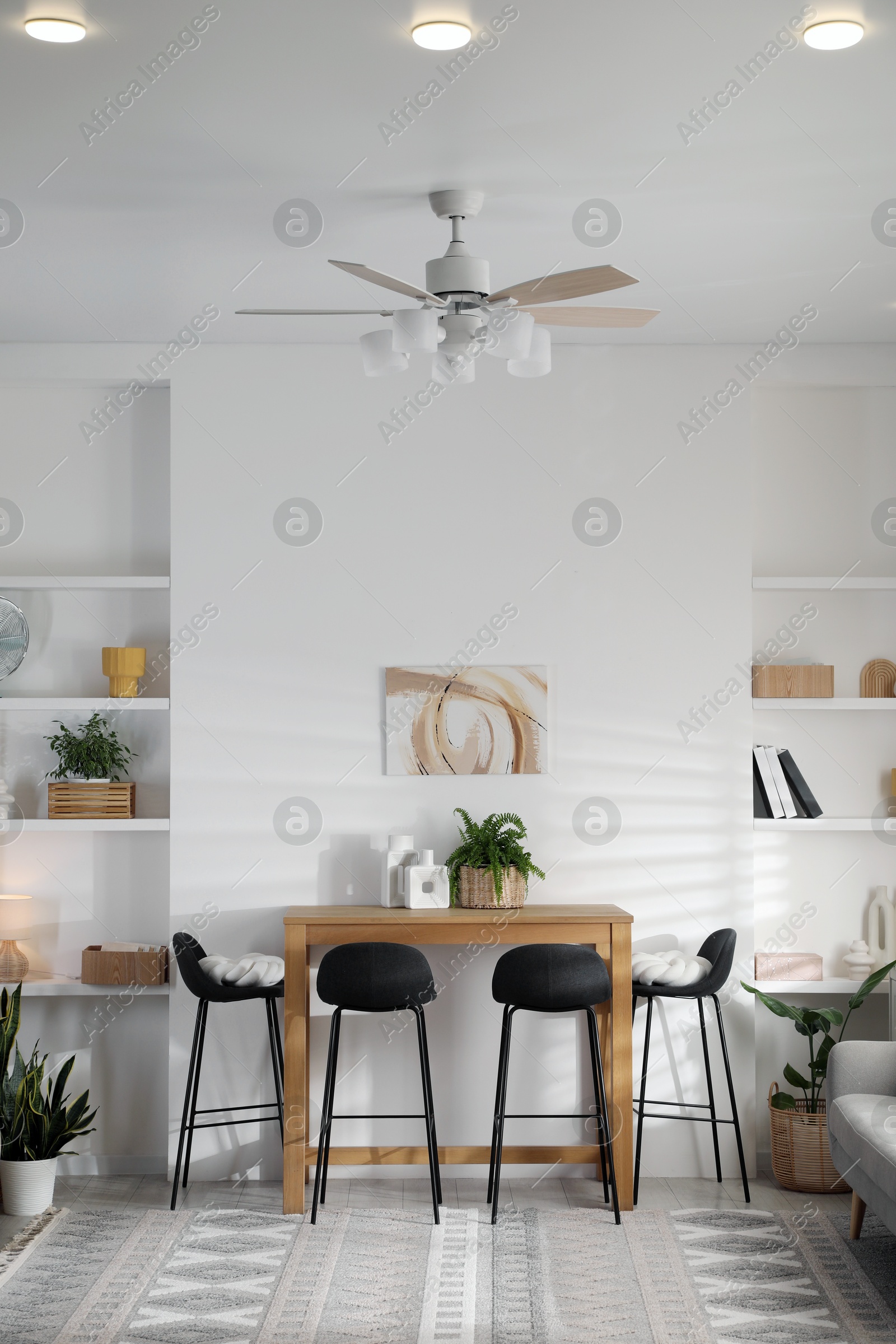 Photo of Bar stools near table in room. Interior design