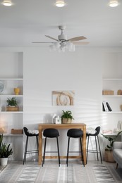 Photo of Bar stools near table in room. Interior design