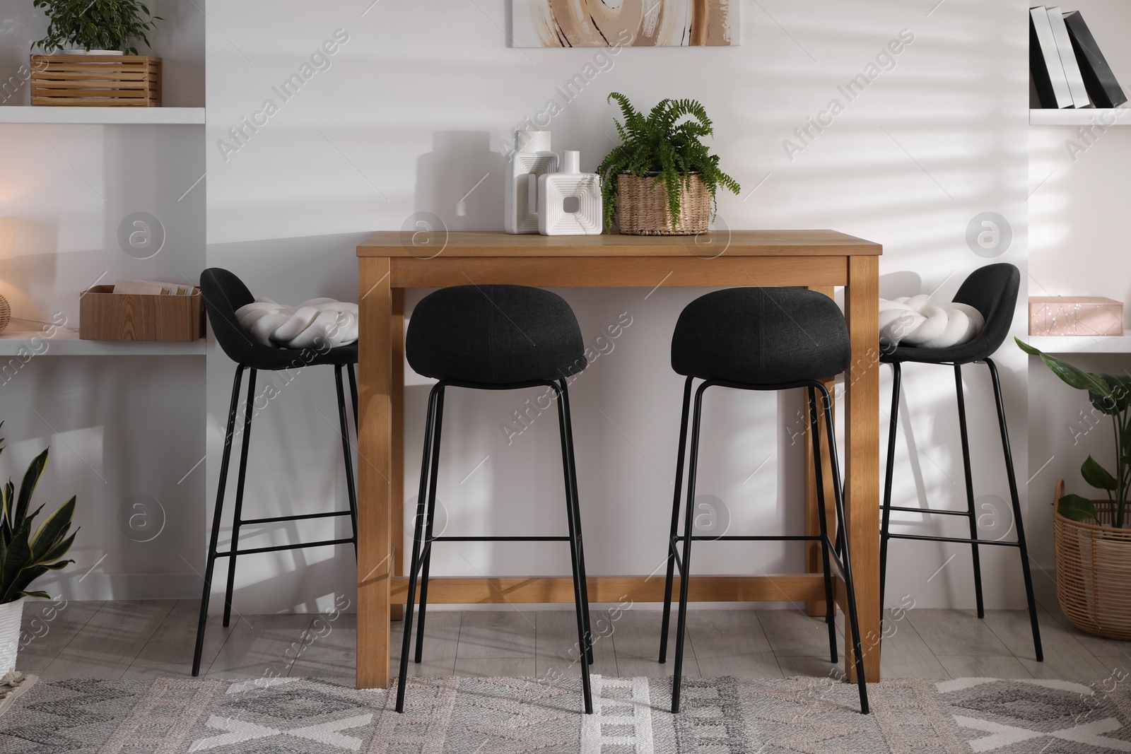 Photo of Bar stools near table in room. Interior design