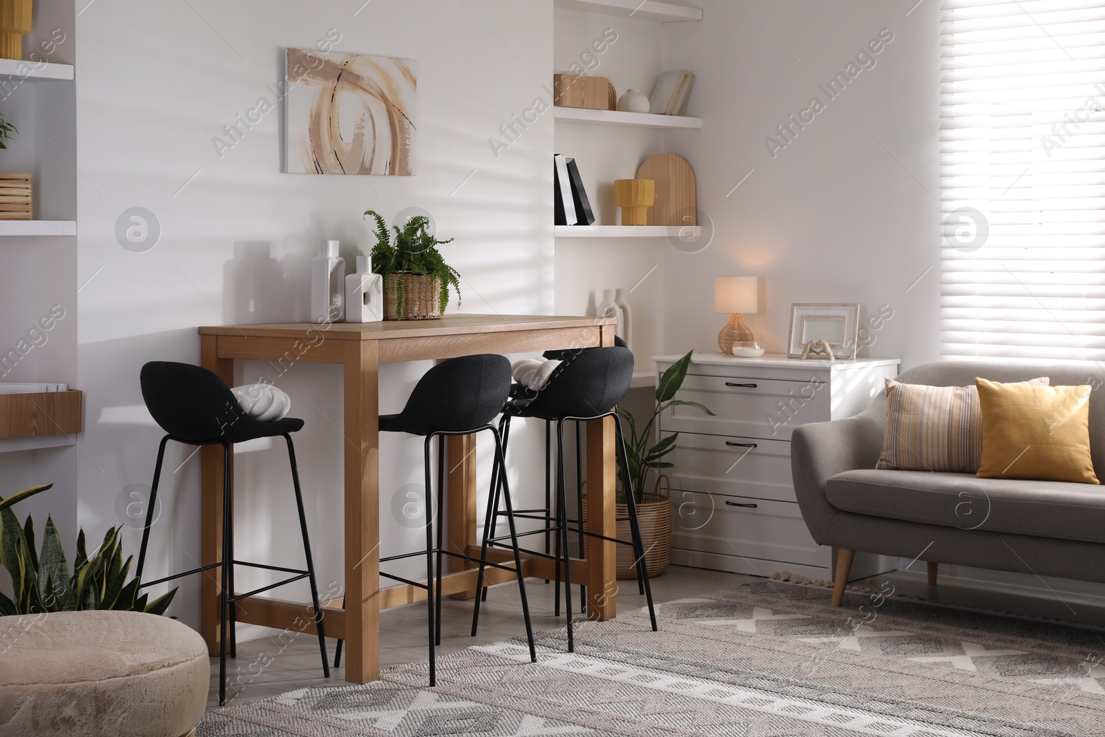 Photo of Bar stools near table in room. Interior design