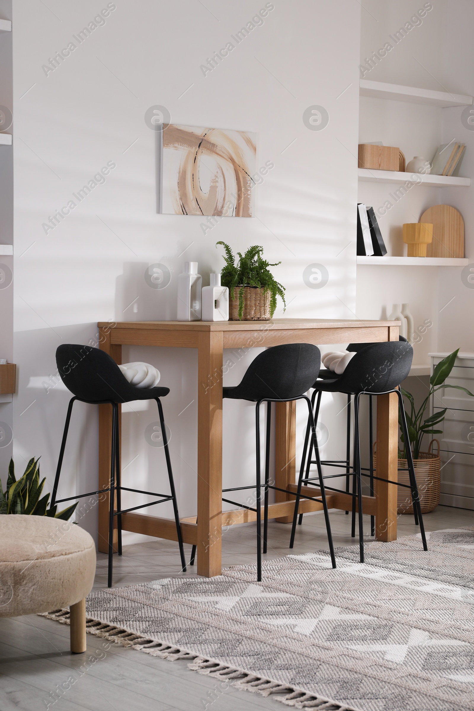 Photo of Bar stools near table in room. Interior design