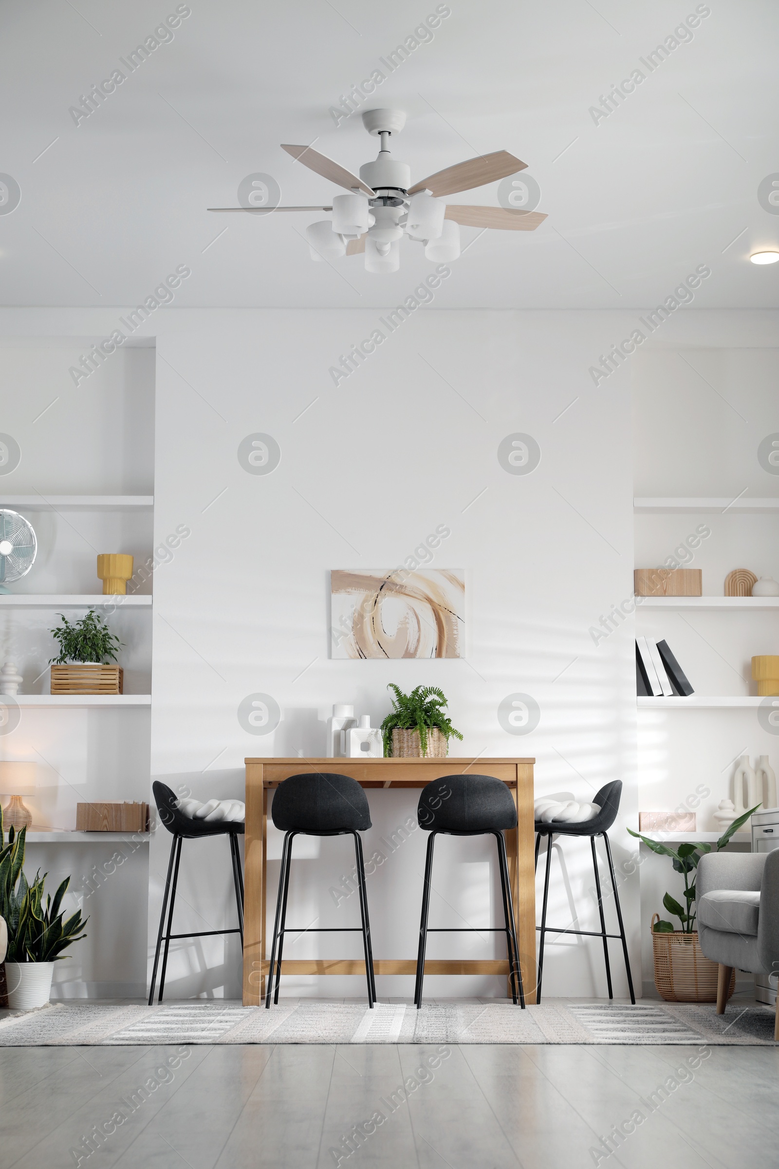 Photo of Bar stools near table in room. Interior design