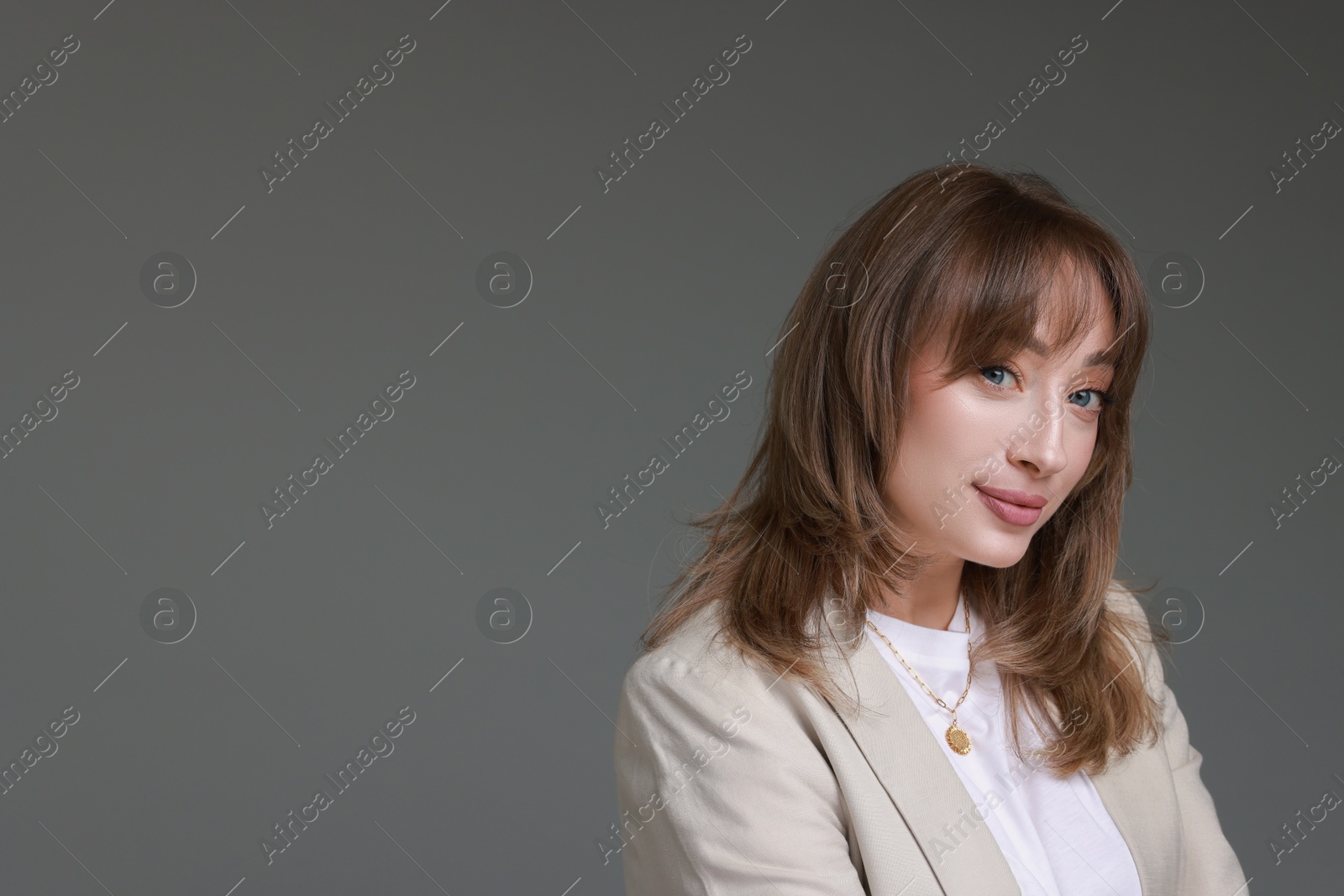 Photo of Attractive woman with stylish haircut on grey background, space for text