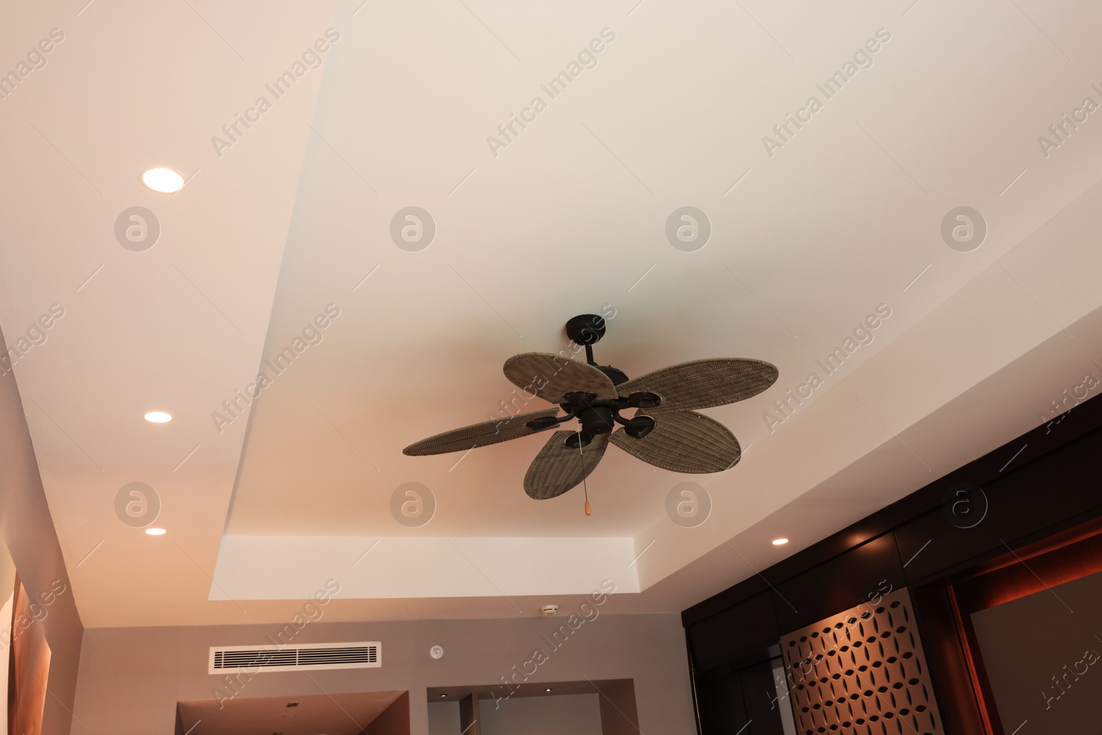 Photo of Modern ceiling fan indoors, low angle view