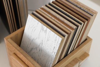 Photo of Different samples of wooden flooring on white table, closeup