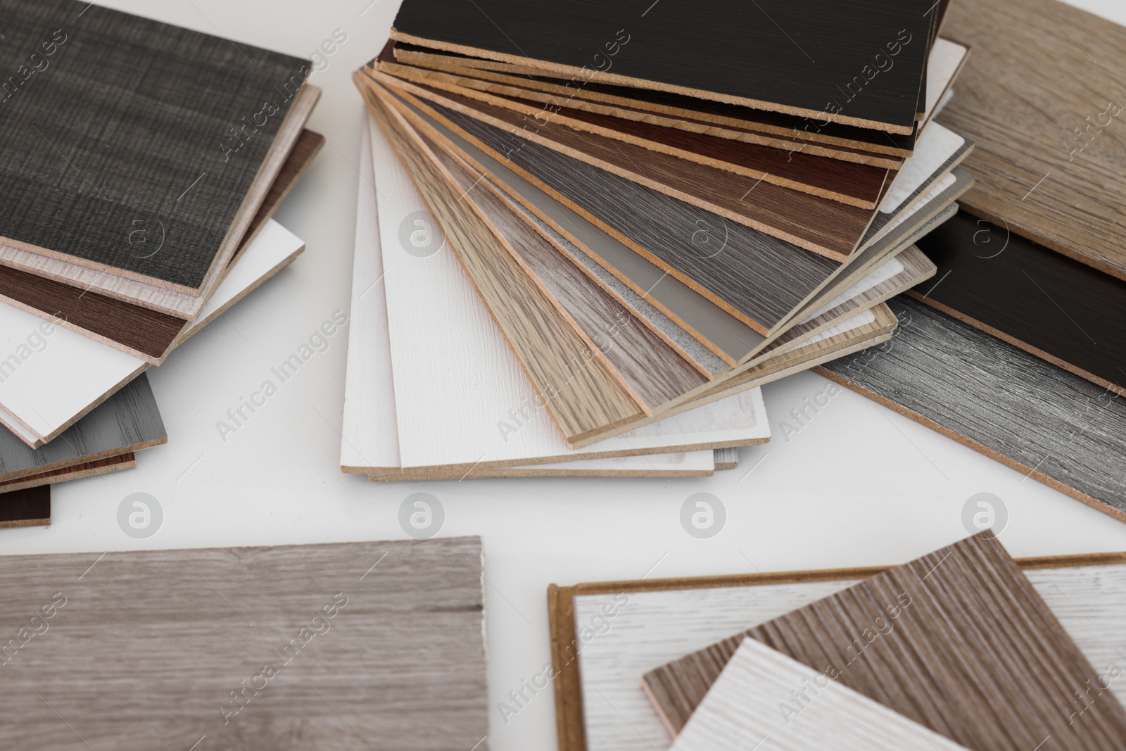 Photo of Different samples of wooden flooring on white table