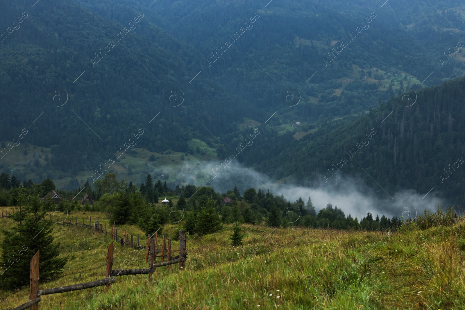 Photo of Picturesque view of beautiful mountains and wooden fence