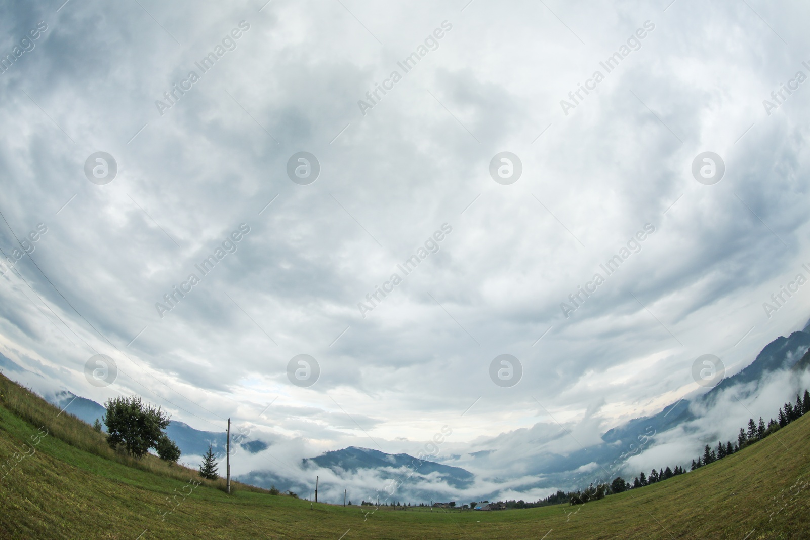 Photo of Picturesque view of beautiful mountains covered with fog. Fisheye lens effect