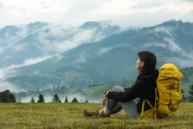 Photo of Young hiker with backpack in mountains. space for text