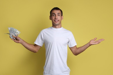 Man with dollar banknotes on yellow background