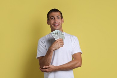 Man with dollar banknotes on yellow background