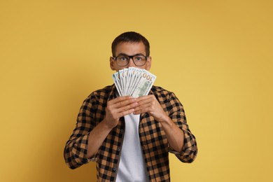 Man with dollar banknotes on yellow background