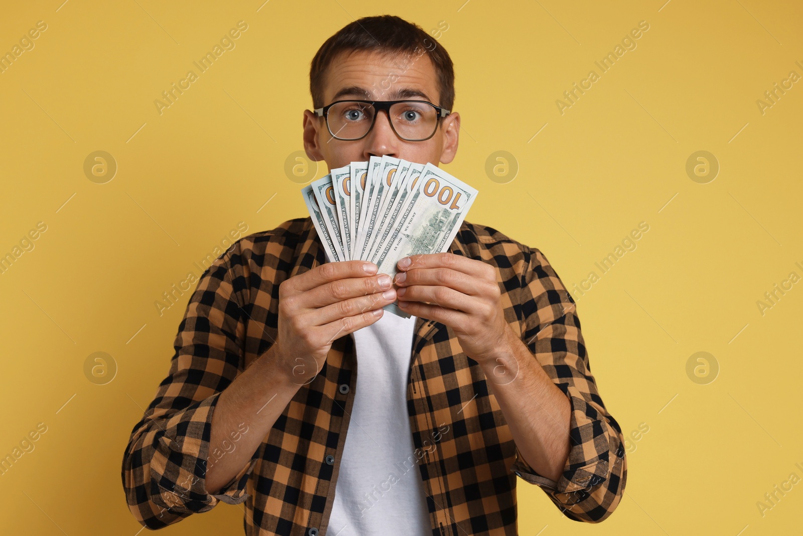 Photo of Man with dollar banknotes on yellow background